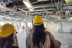 Interior design students observe a space under construction.